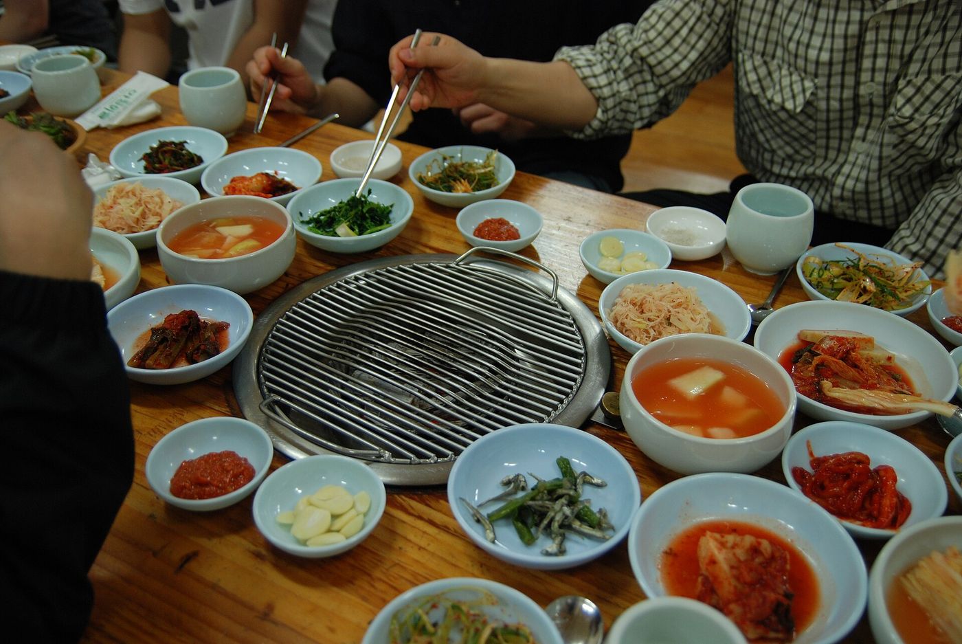 Bếp nướng giữa bàn và các đĩa banchan bày xung quanh