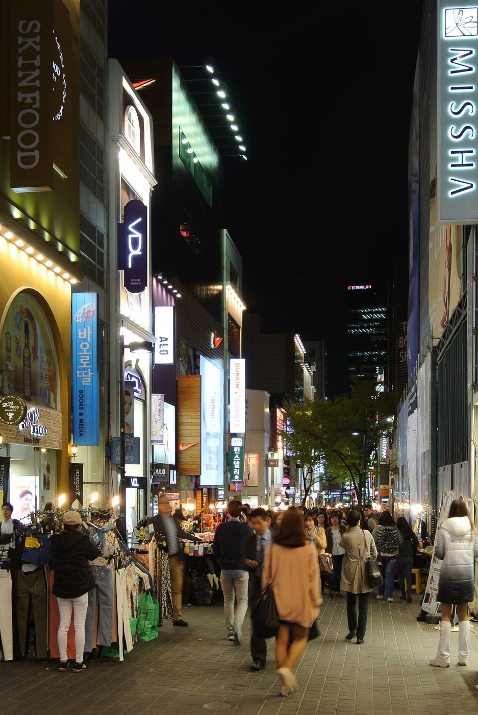 Một con phố mua sắm ở Myeongdong lúc tối, hai bên là cửa hàng mỹ phẩm