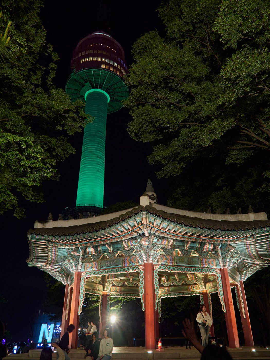 Tháp N Seoul chiếu đèn ban đêm, phía trước là một ngôi đình truyền thống trên núi Namsan